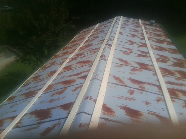 Rusted metal roof panels with new wood purlins before replacement — Storm Damage Roof Repair in Argusville by Roofing Brothers